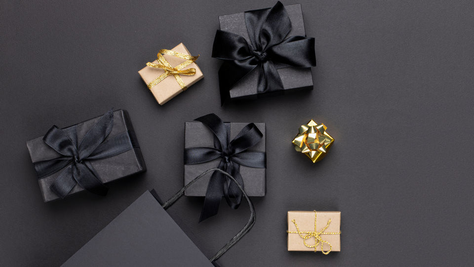 black paper shopping bags and gift boxes on black background