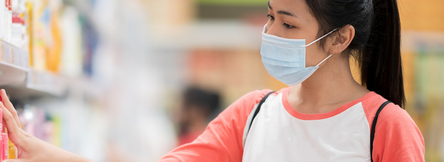 woman wears a face mask shopping in a supermarket