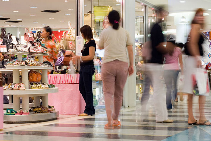 shoppers in mall near women's handbag and accessories store
