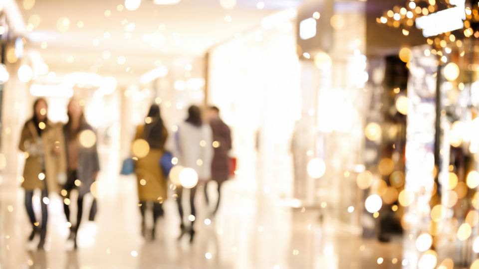 artistically blurred image of shoppers in a retail shopping center