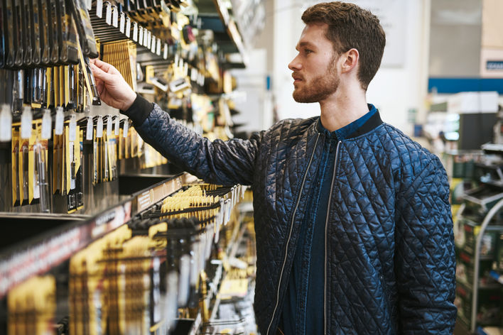 male shopper inspecting items on store display