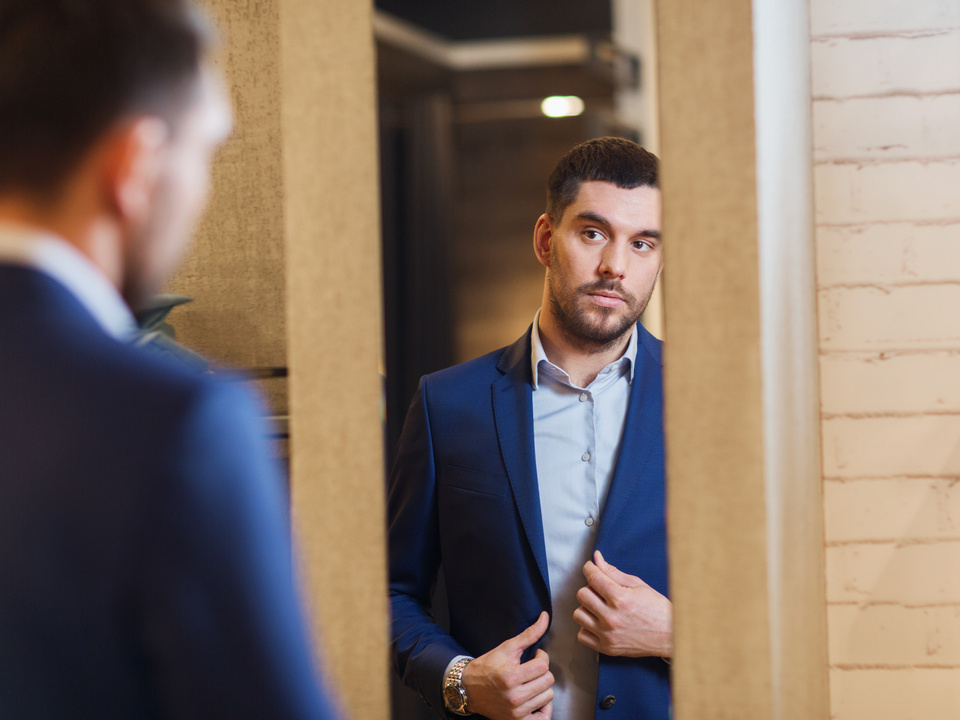 male customer trying on clothes in retail store fitting room