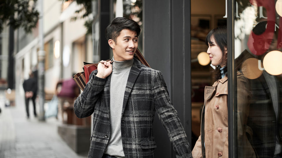 male female couple leaving retail store with several shopping bags