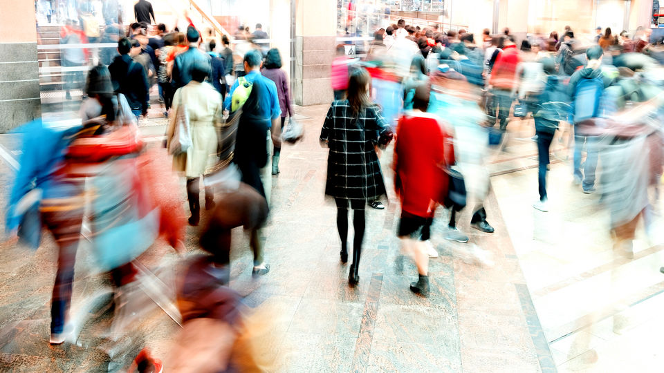 blurred crowd of shoppers in a busy retail shopping mall
