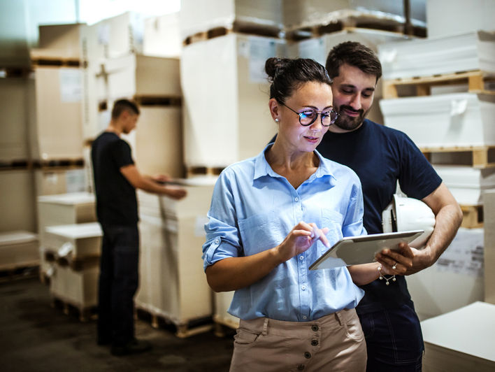 Workers in warehouse accessing retail analytics mobile device