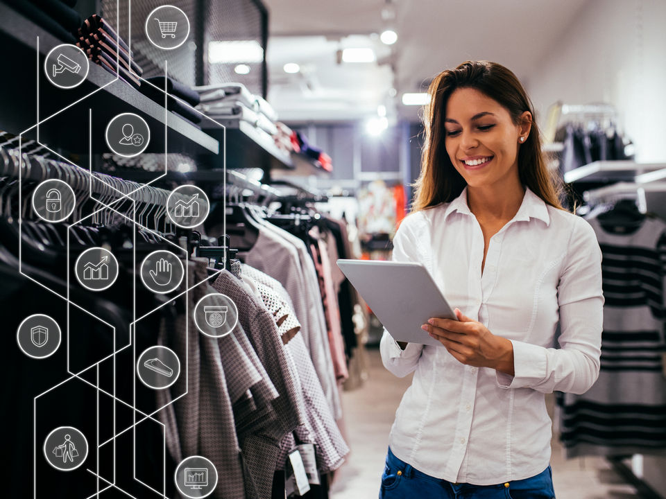 female retail associate holding tablet and reviewing shopper analytics data