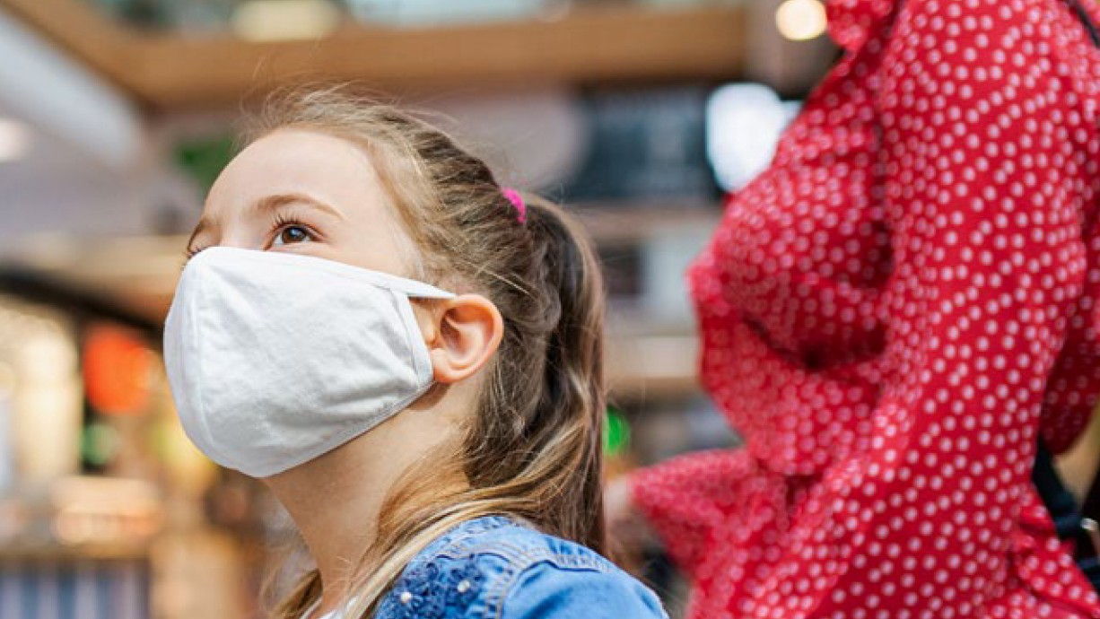 young girl in mask in retail shopping center