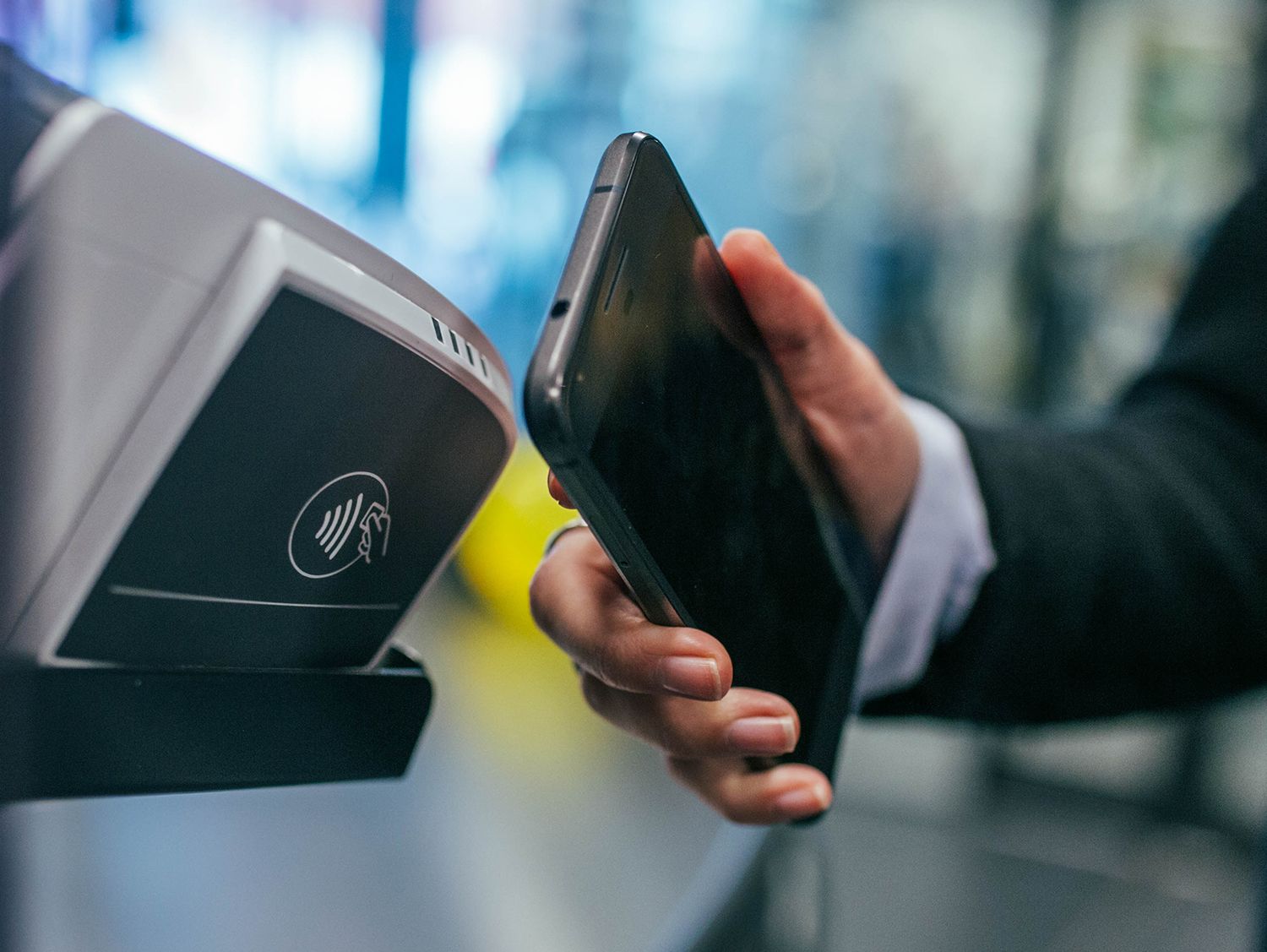 La mano del hombre sosteniendo el celular hasta el escáner