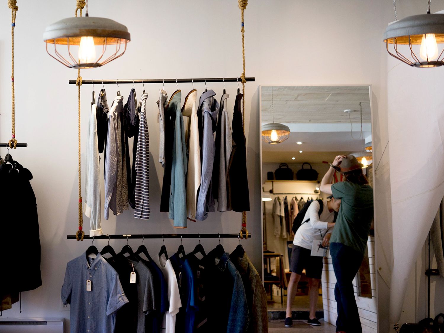 clothes hanging on 2-tiered rack in retail store