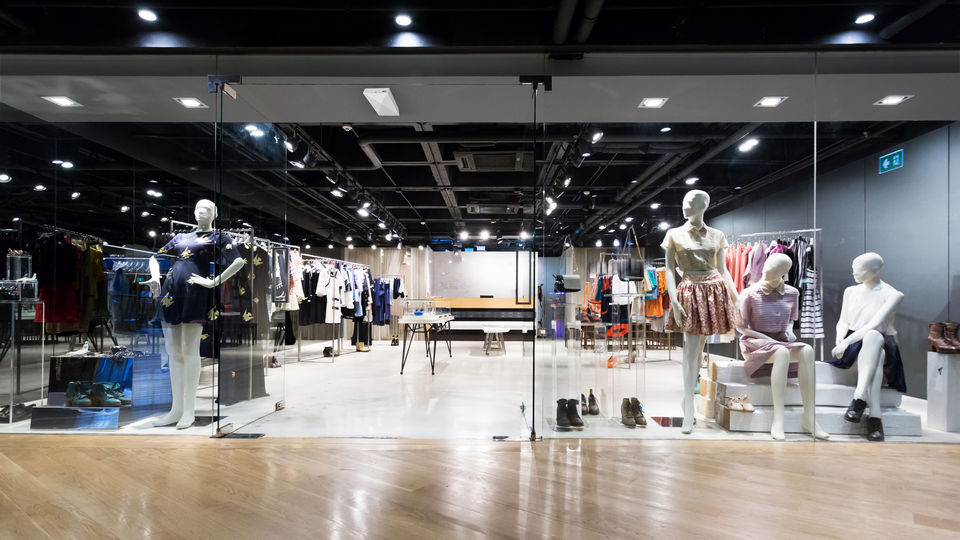 entrance and interior of modern retail apparel store with several mannequins