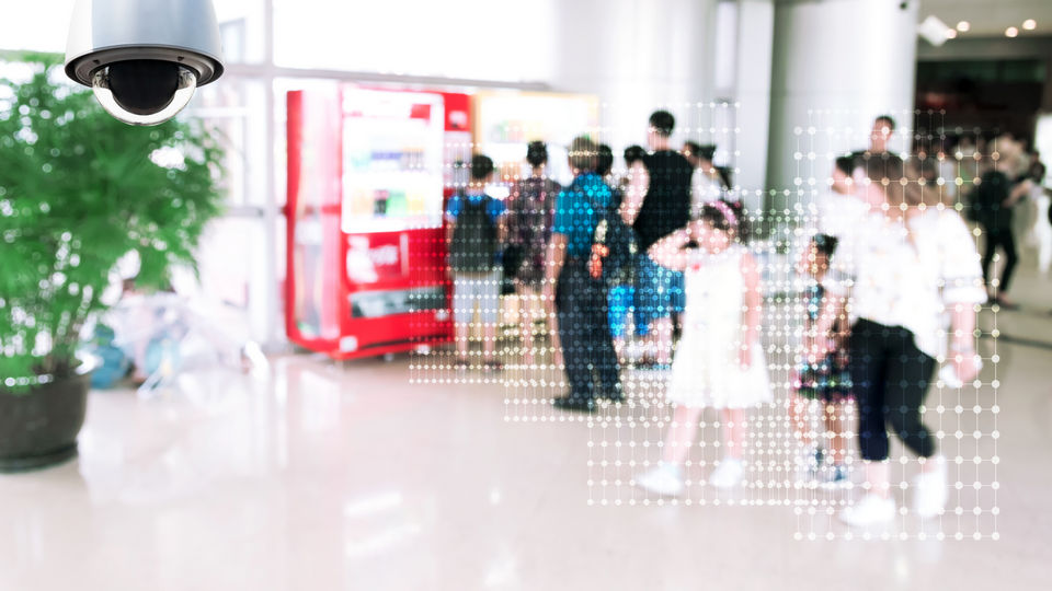 video surveillance camera in retail mall common space with digitized data representation on shoppers