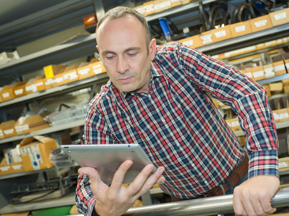 retail associate viewing inventory info on tablet in hardware store